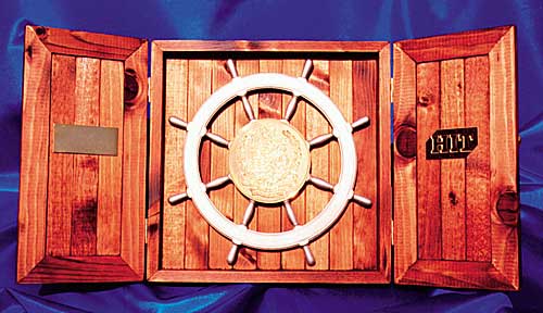 Photograph of ships wheel in a presentation box