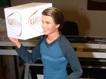 Model of a person carrying a case of Grants Whisky